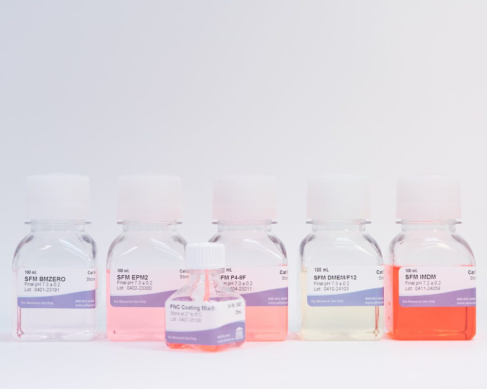 Five laboratory bottles with colorful liquids.