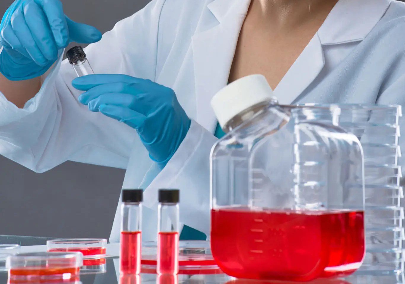 Scientist handling test tubes in laboratory setting.